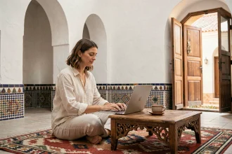 Femme en télétravail dans un riad traditionnel d'Essaouira avec carrelage zellige et cour intérieure